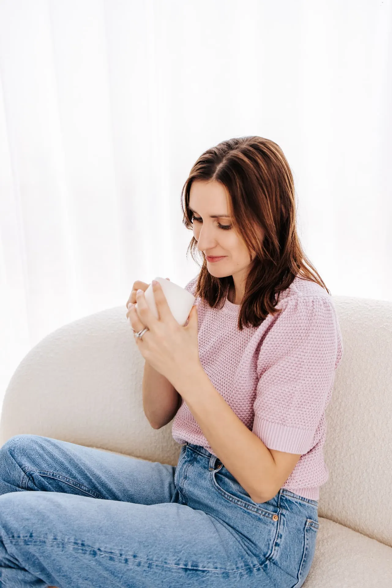 Melanie met een kopje op de sofa